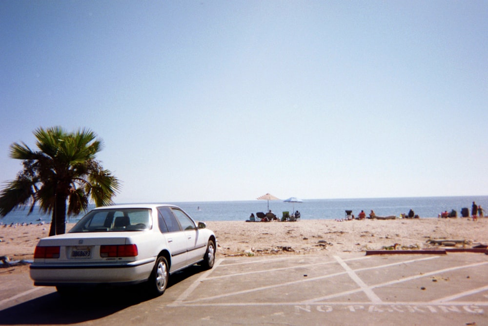 silver suv on brown sand near body of water during daytime