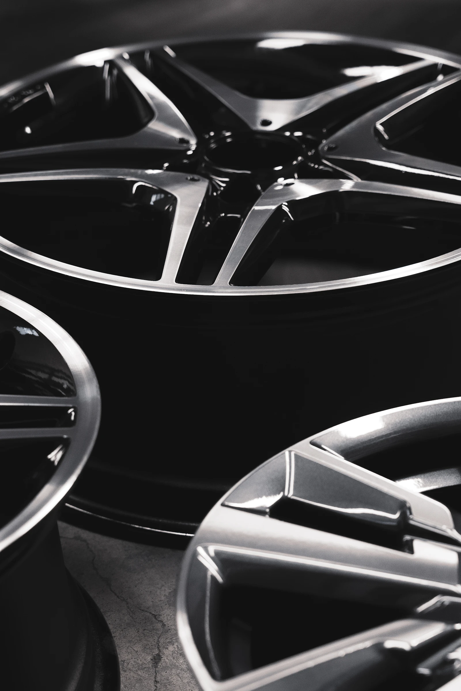 A stack of unfinished alloy wheels, their machined faces dull and waiting to be refinished.