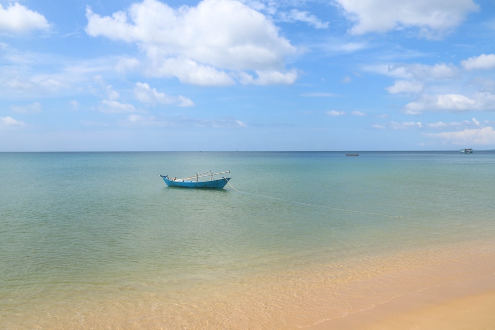 white and blue boat on sea under blue sky during daytime