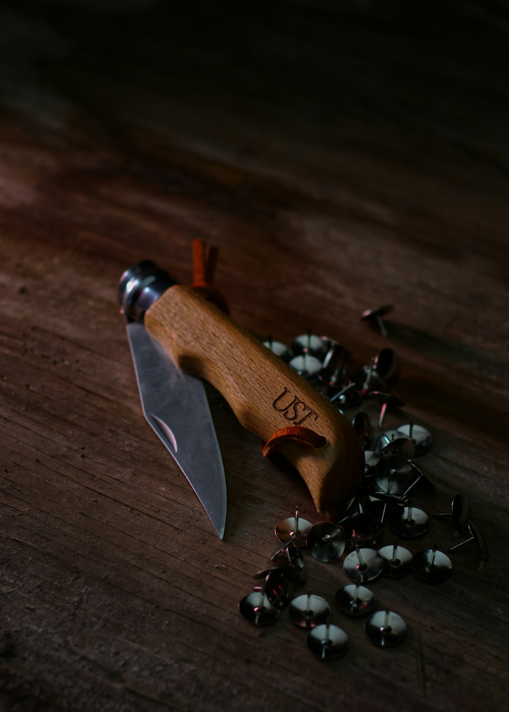 brown and black folding knife on brown wooden table