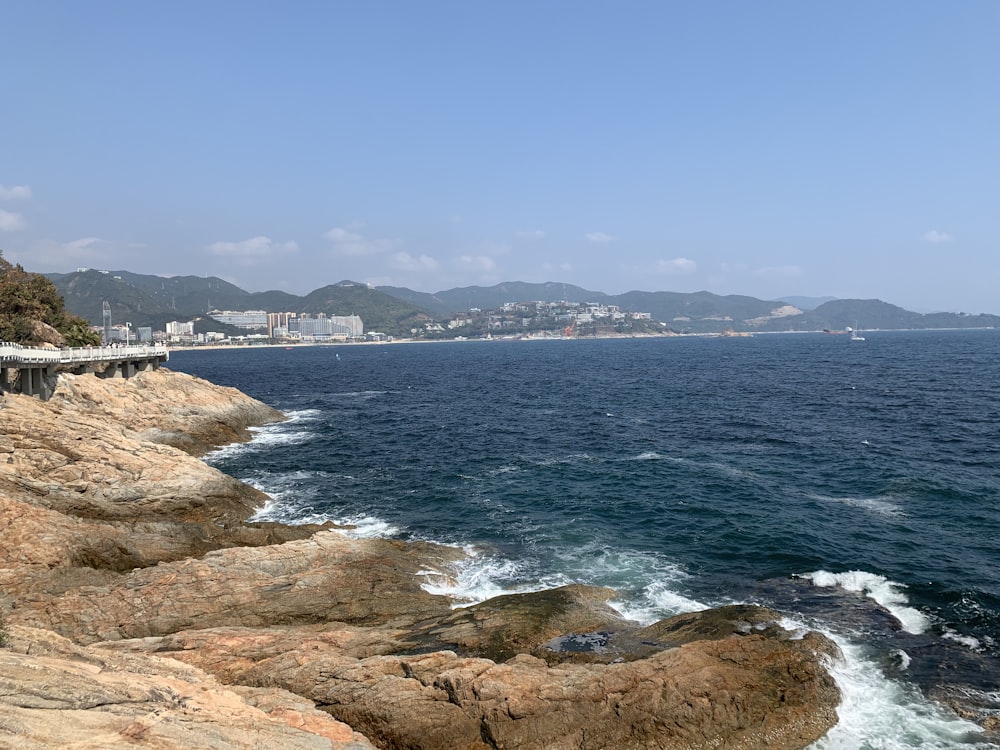 brown rocky shore near body of water during daytime