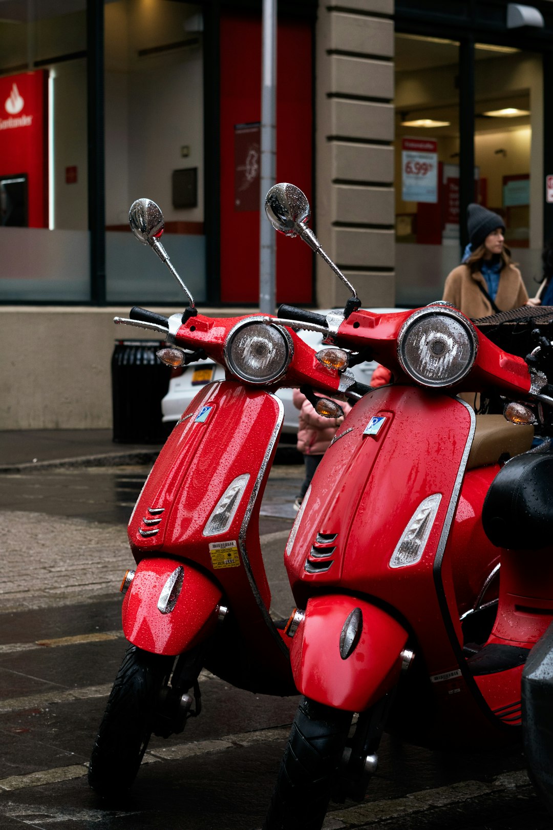 red motor scooter parked on sidewalk during daytime