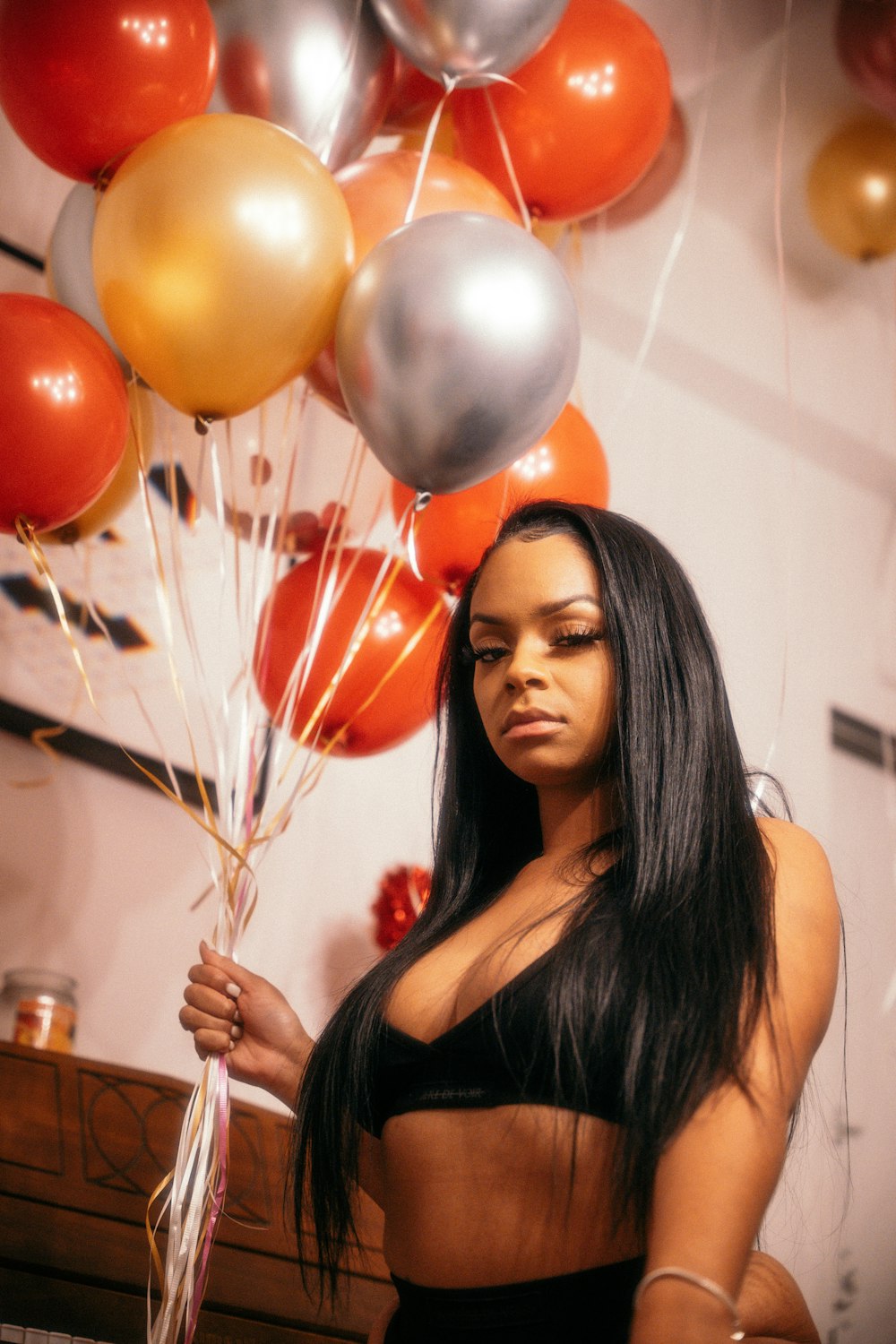 woman in black tank top holding balloons