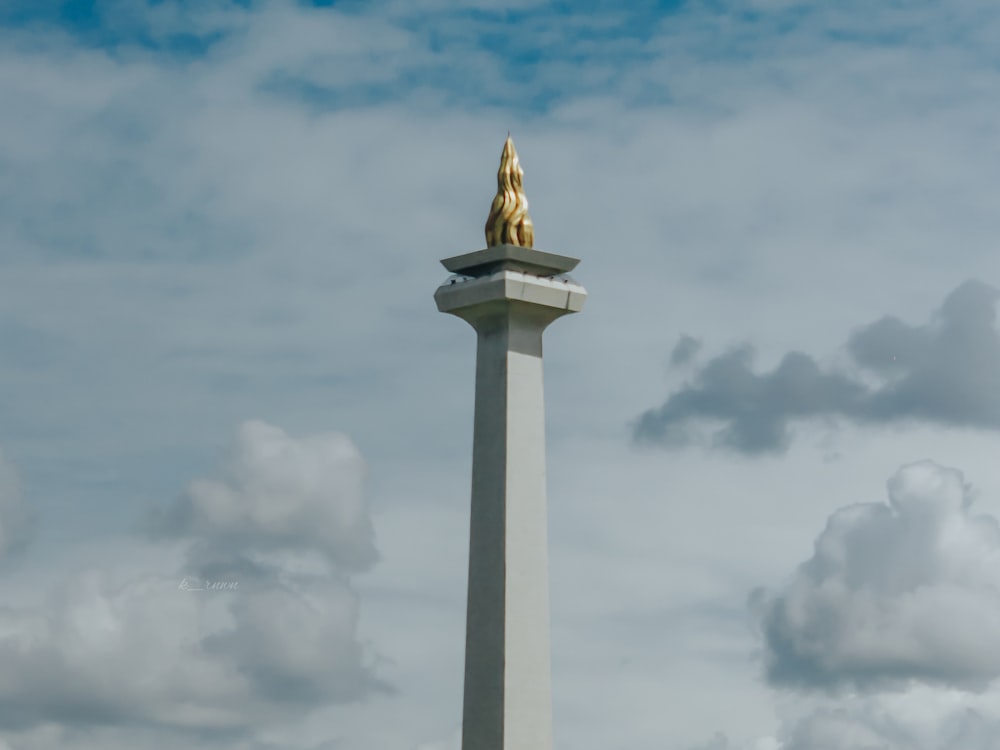 torre di cemento bianco sotto il cielo nuvoloso durante il giorno