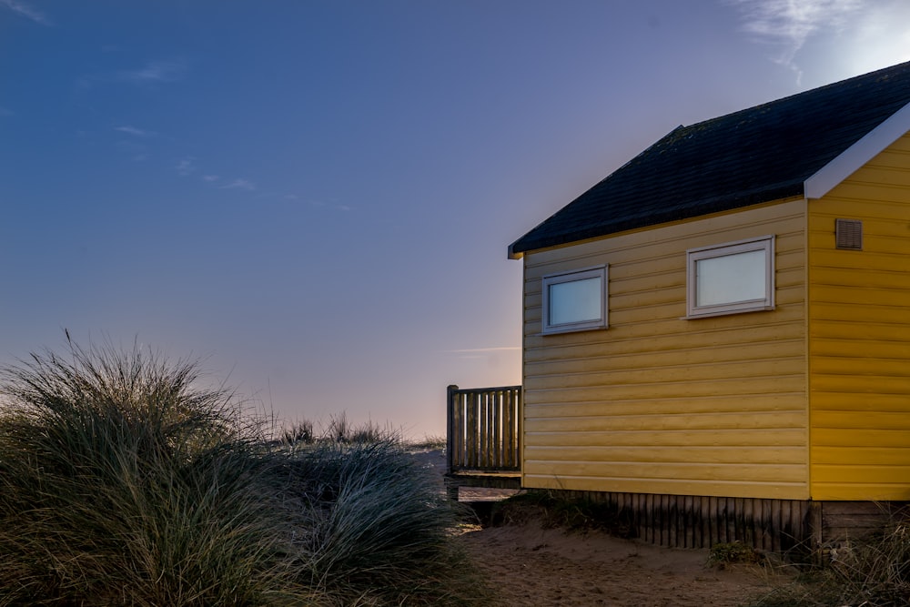 maison en bois jaune et noir sous le ciel bleu pendant la journée