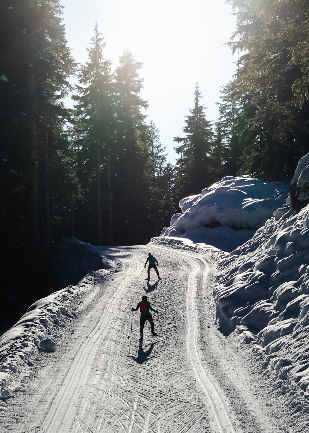 person in red jacket and black pants walking on snow covered ground during daytime