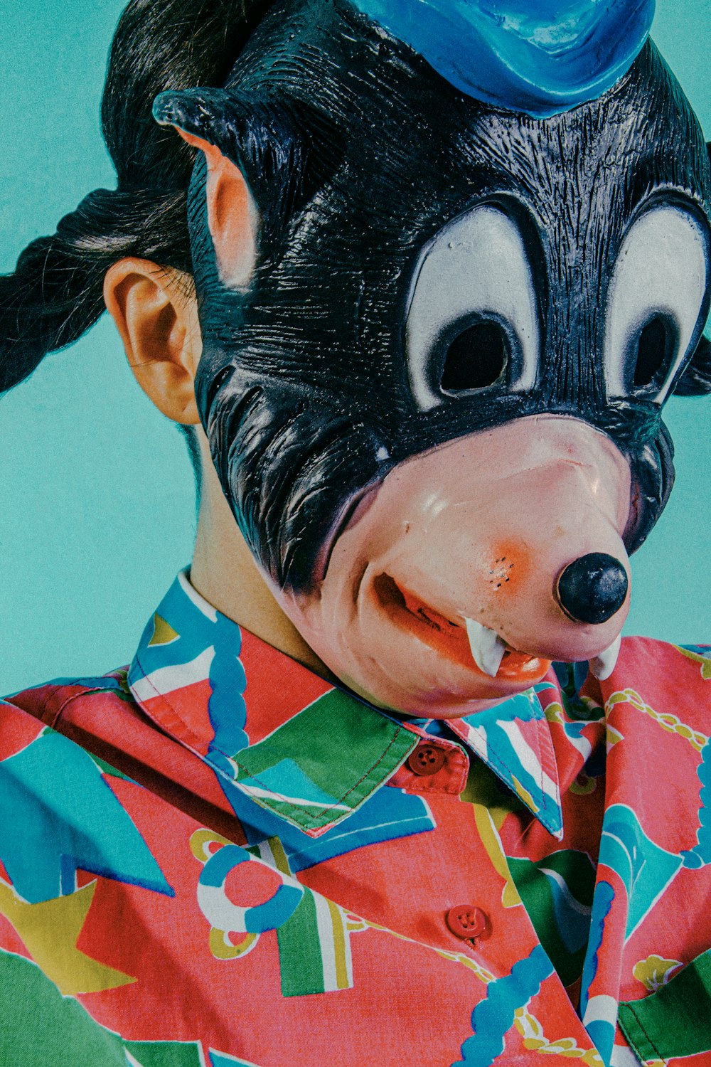 woman in blue and red collared shirt with black and white face paint