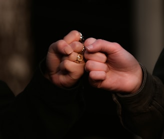 person holding gold ring in dark room