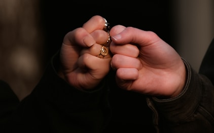 person holding gold ring in dark room