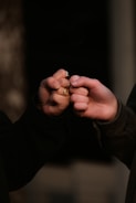 person holding gold ring in dark room