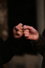 person holding gold ring in dark room