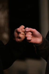 person holding gold ring in dark room