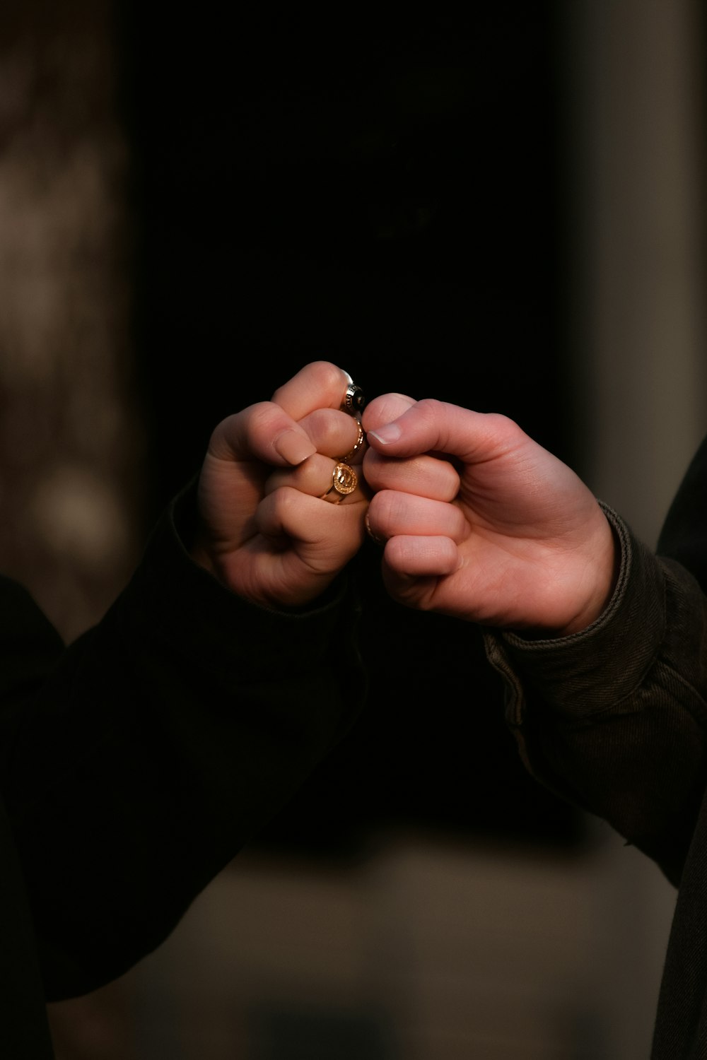 person holding gold ring in dark room