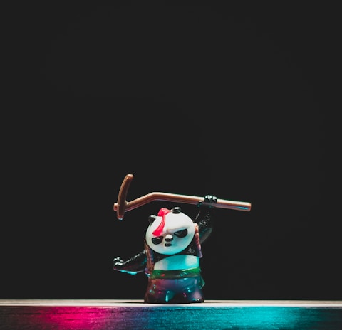 man in green shirt and black pants holding black and white stick figurine