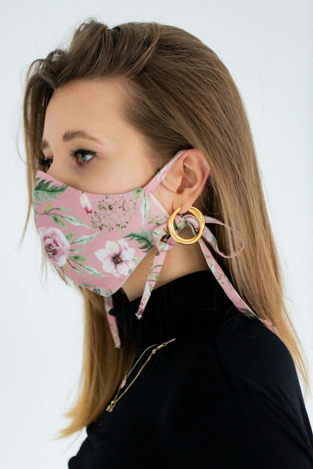 woman in black shirt with white green floral mask