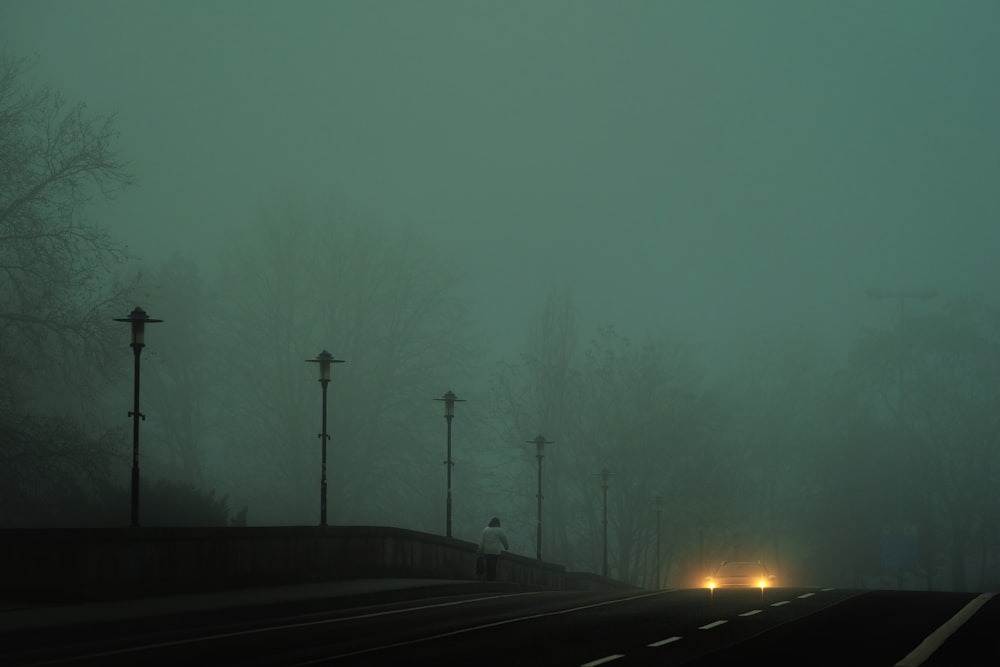 Carretera de asfalto negro durante un día de niebla