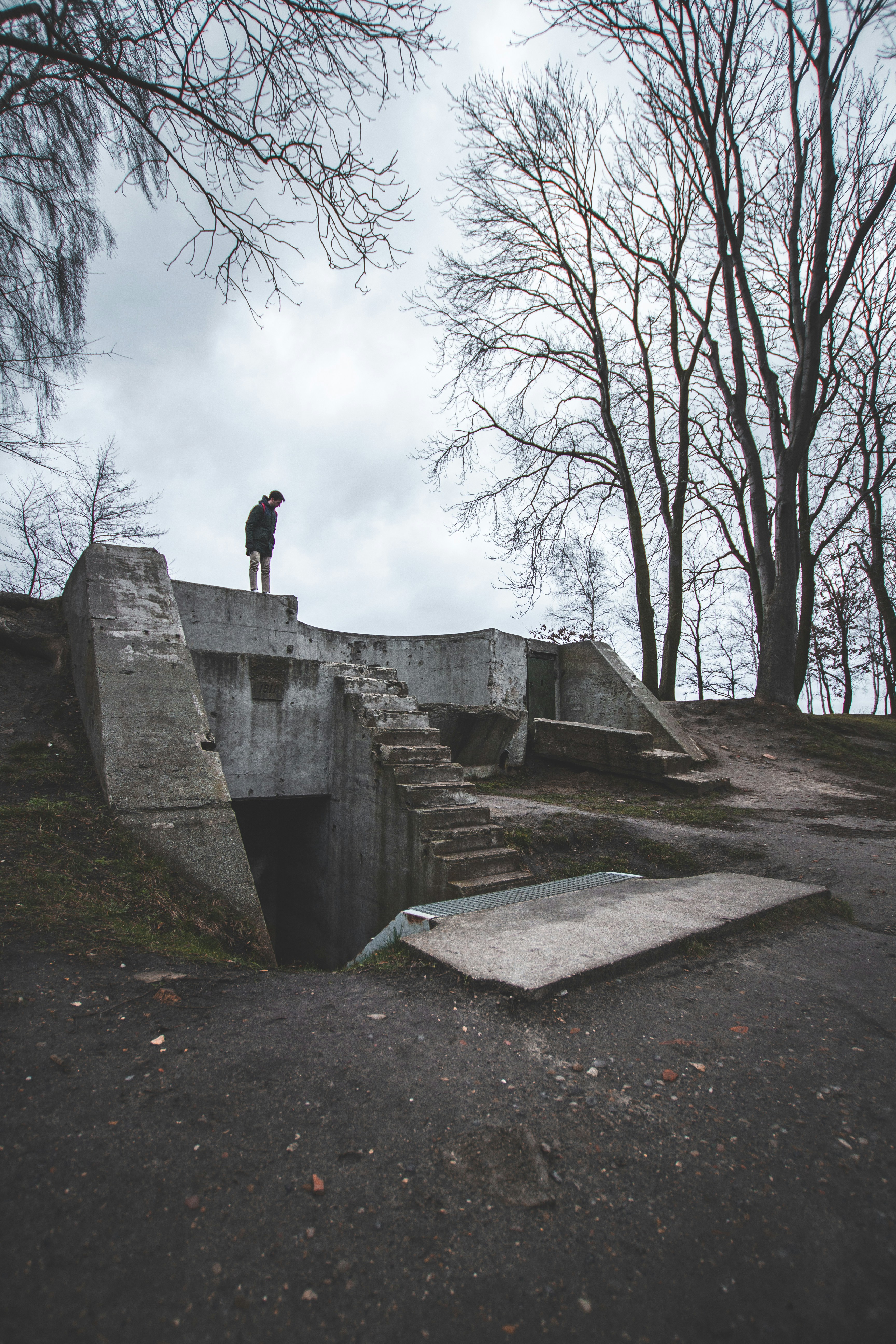 person in black jacket standing on gray concrete wall during daytime