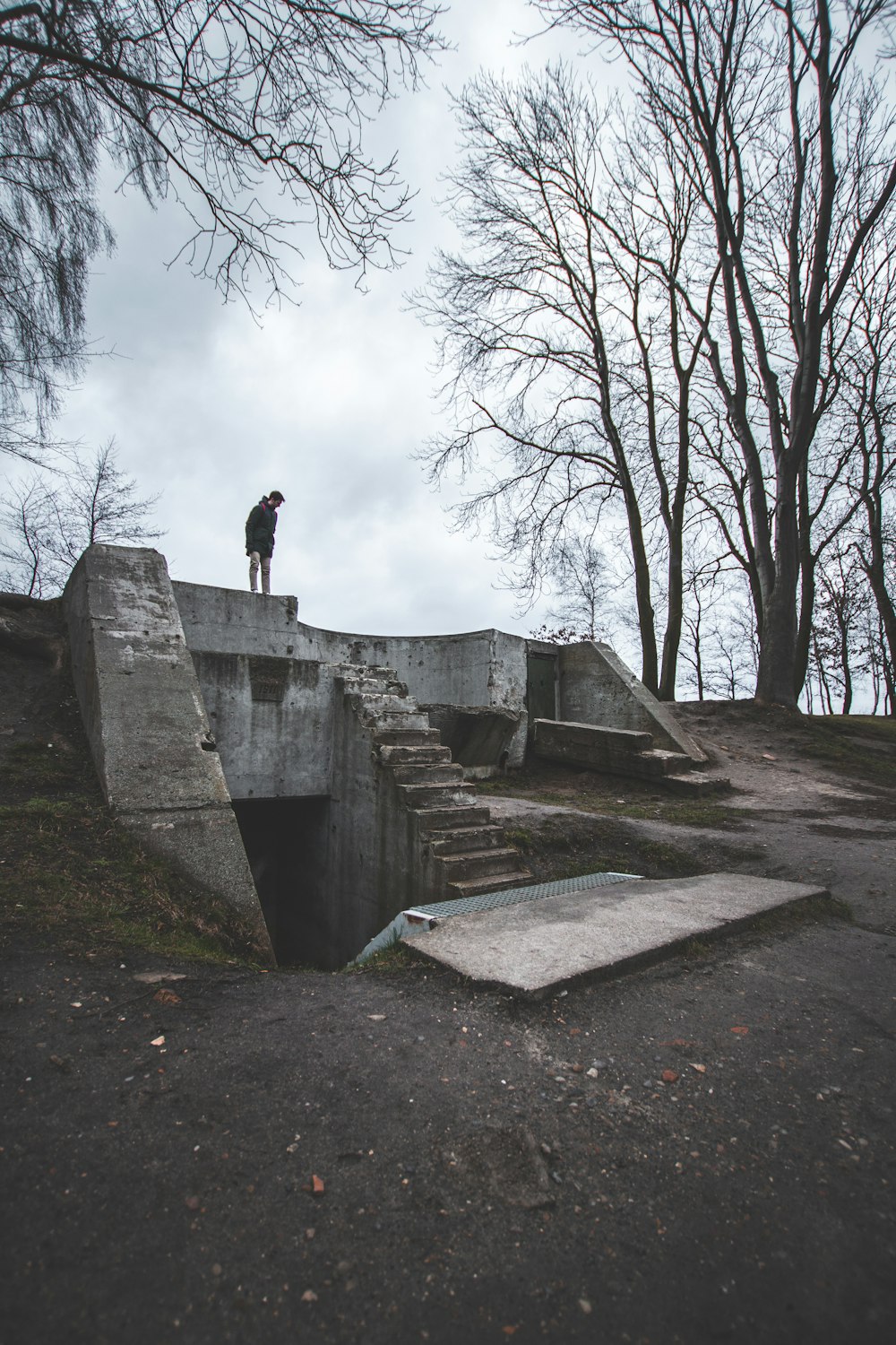 person in black jacket standing on gray concrete wall during daytime