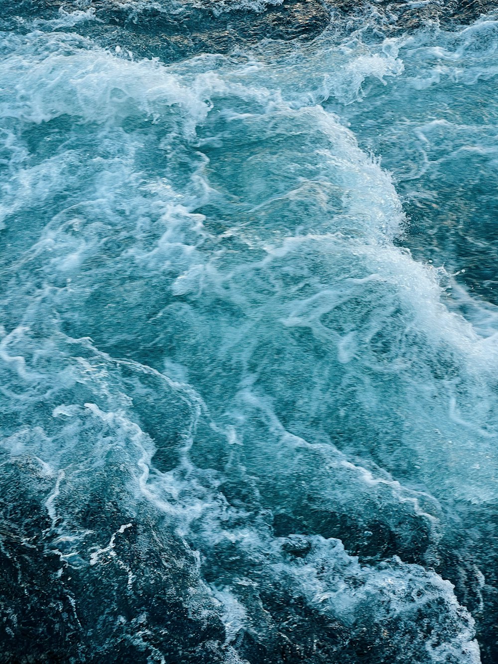 water waves on blue body of water