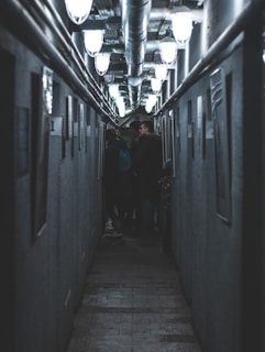 man in black jacket walking on hallway