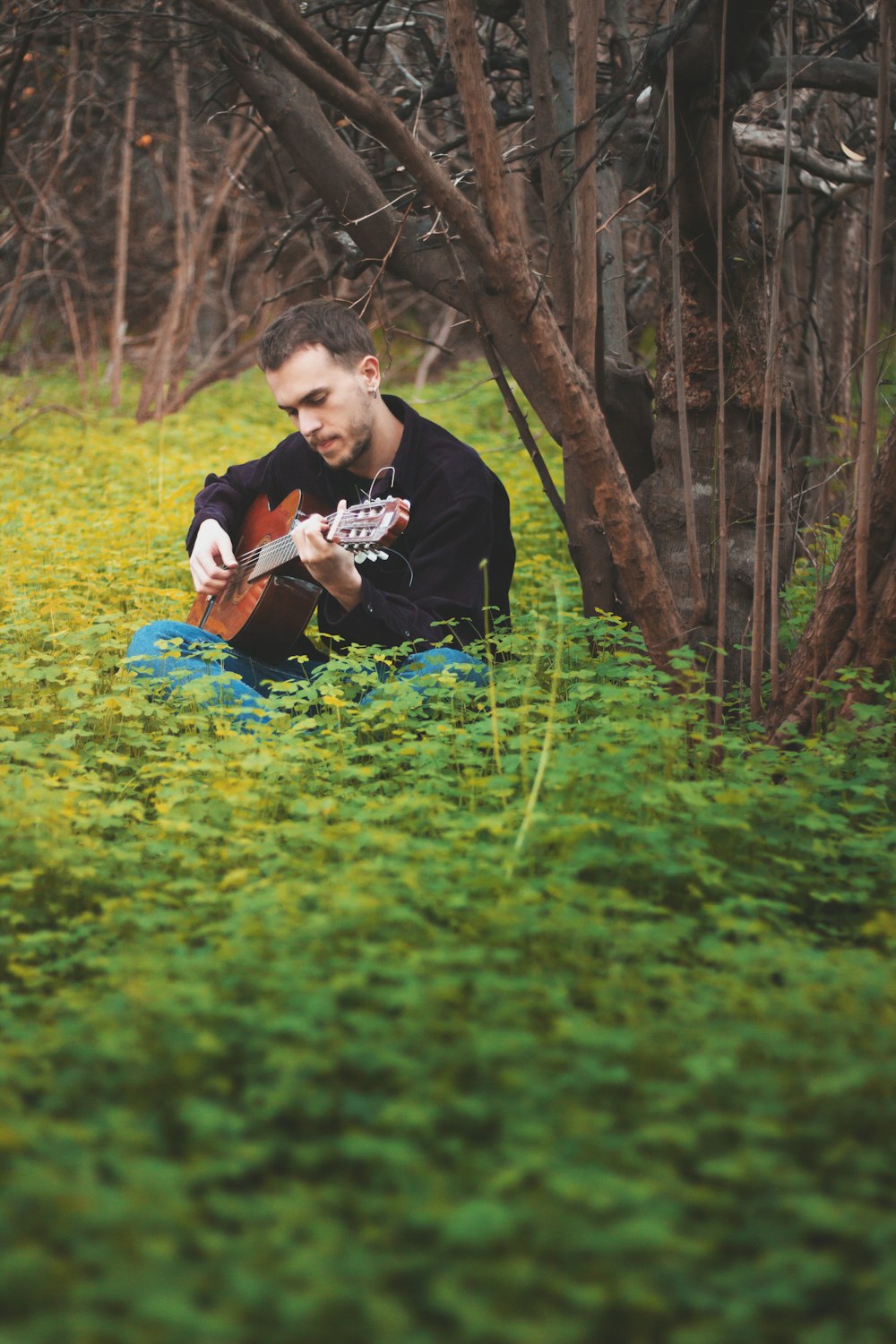 man in black crew neck t-shirt sitting on blue plastic mat on green grass field