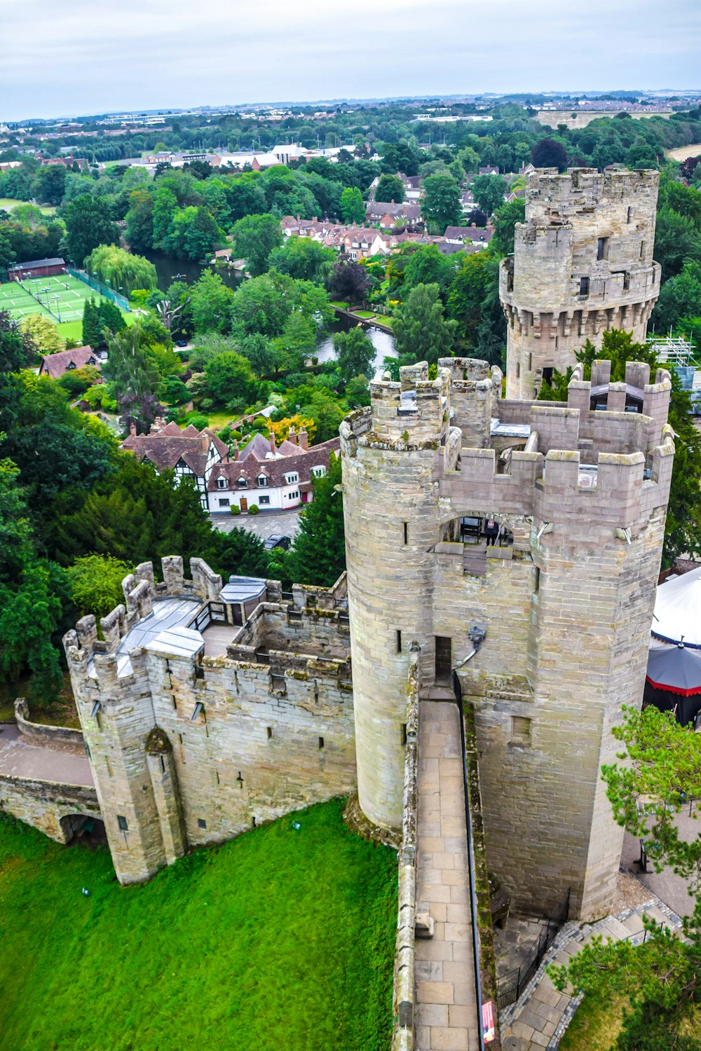 Château en béton gris entouré d’arbres verts pendant la journée