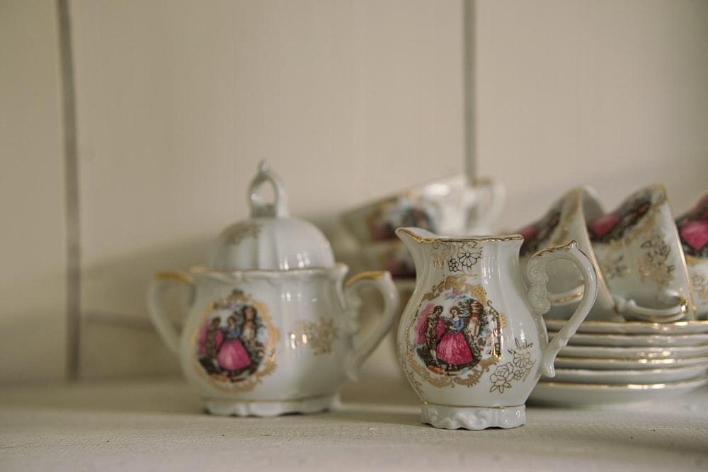 white and red floral ceramic teapot