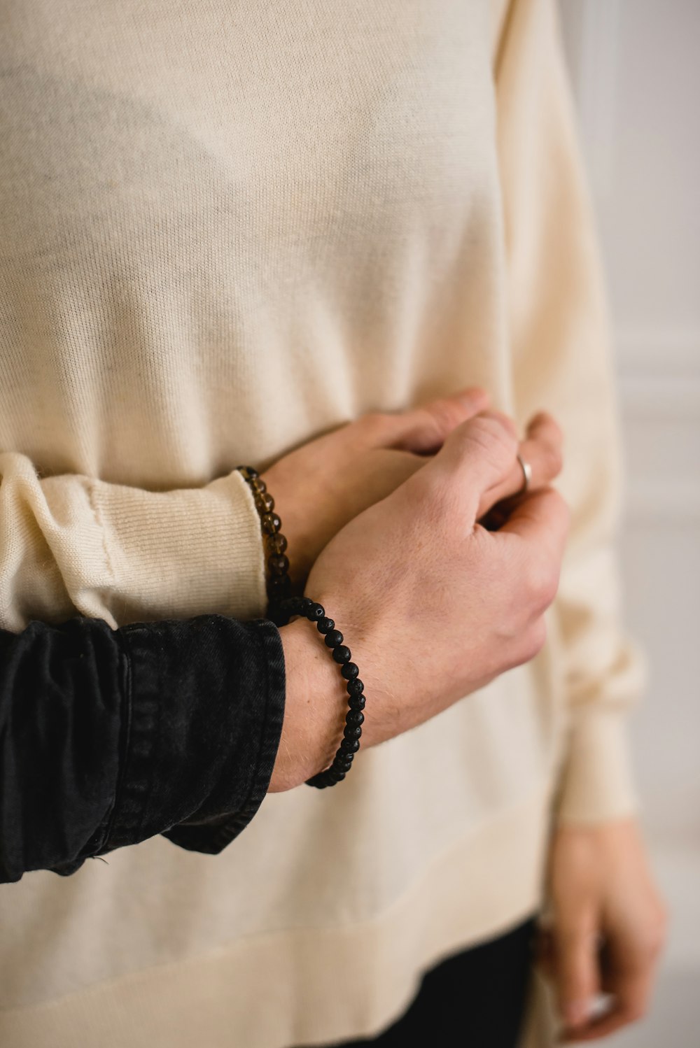 person in black long sleeve shirt wearing black and silver bracelet