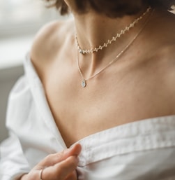 woman in white off shoulder shirt wearing silver necklace