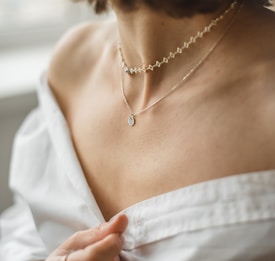 woman in white off shoulder shirt wearing silver necklace