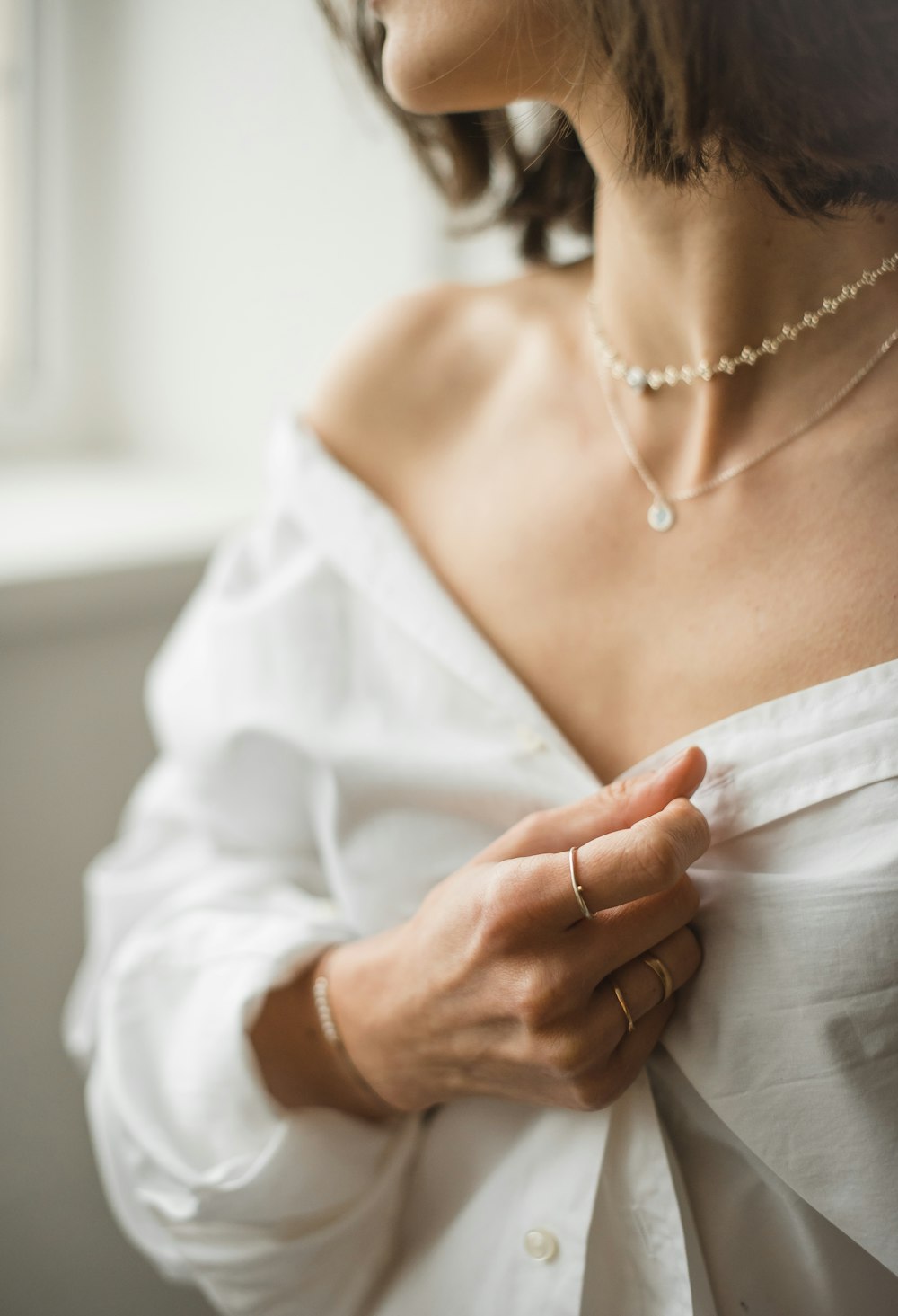 woman in white dress wearing gold necklace