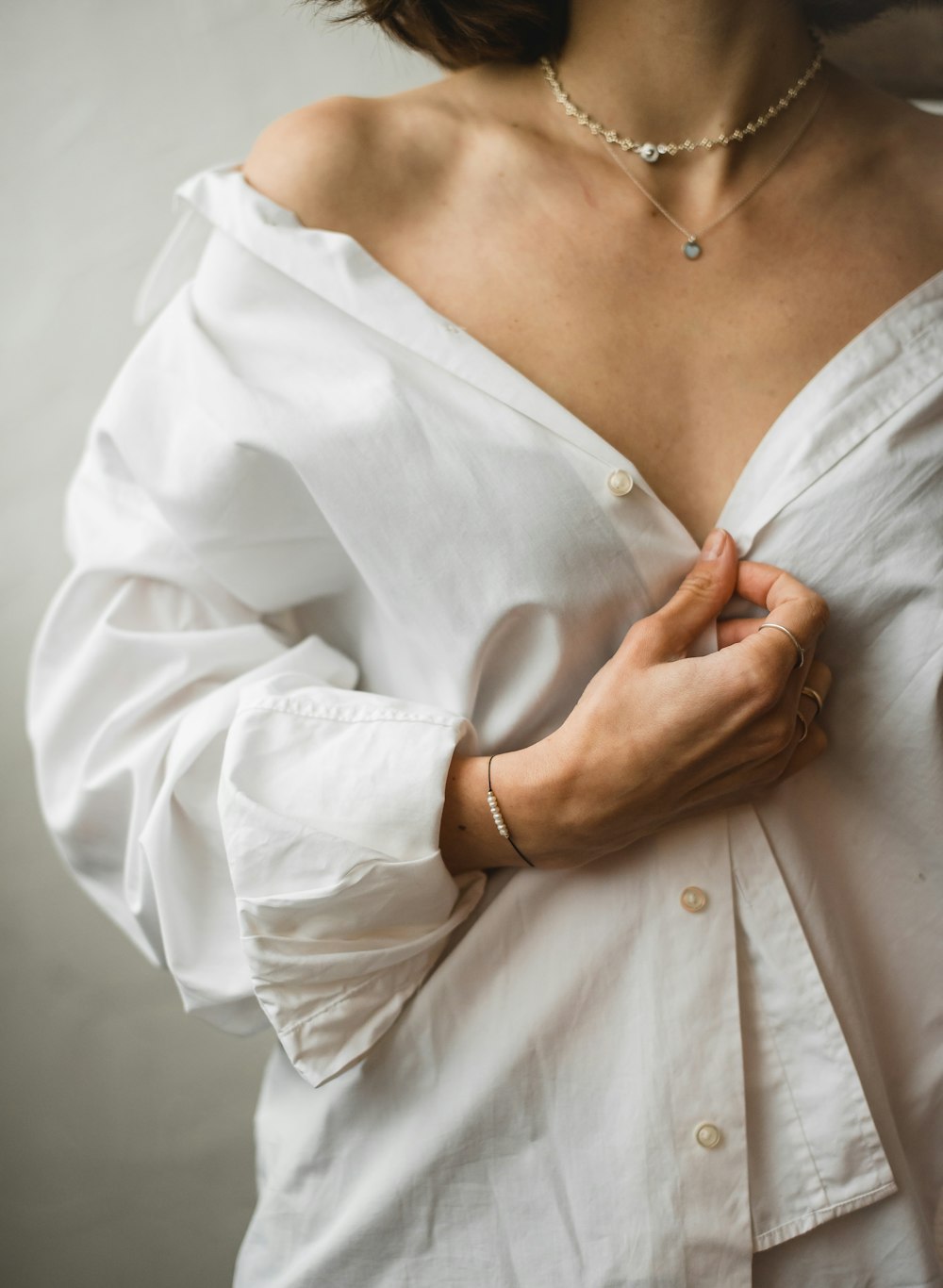 woman in white dress shirt wearing silver necklace