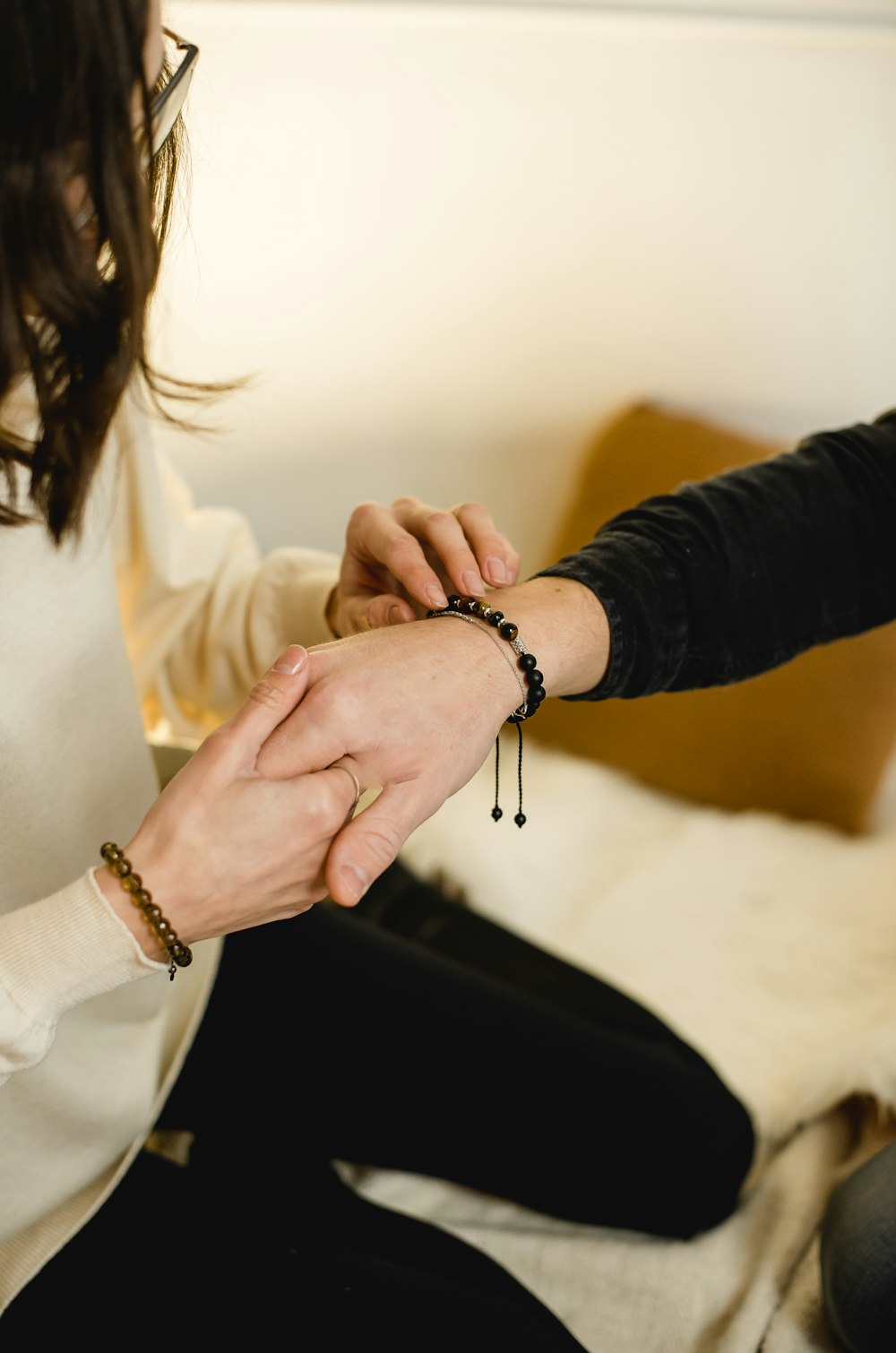 woman in black long sleeve shirt holding mans hand