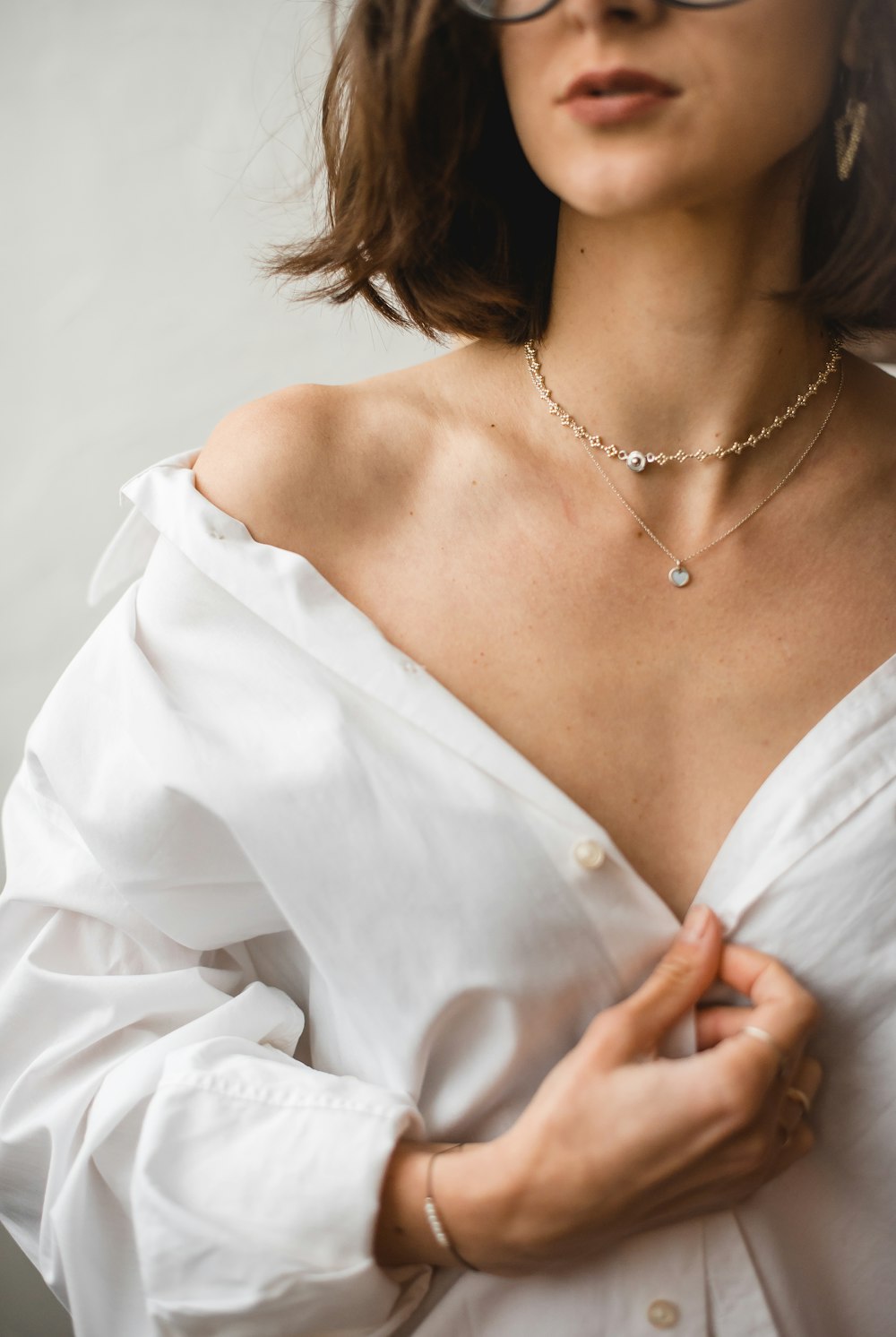 woman in white dress shirt wearing silver necklace