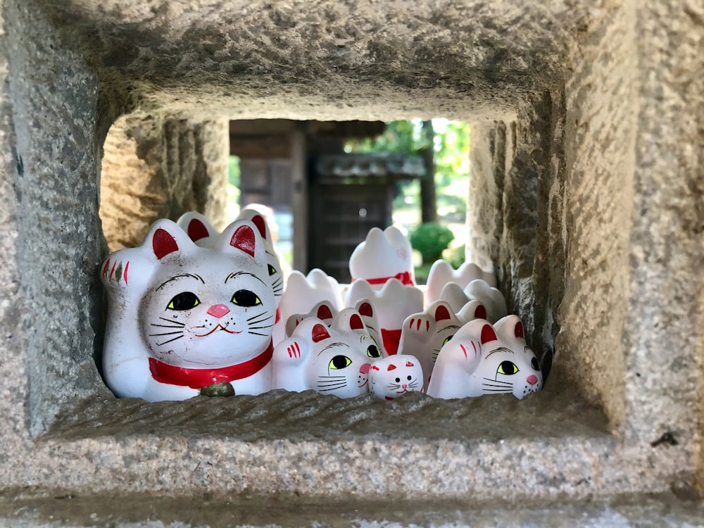 white and red ceramic cat figurines