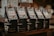 Five packages of Starbucks Reserve coffee with Hawaiian labels are neatly lined up on a wooden surface. The packaging features a dark design with stylized stars and the letter 'R'. Each package has a clip holding a colorful, tropical-themed label that reads 'Hawaii'. The background is softly blurred, creating a cozy and warm ambiance.