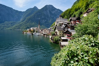 houses near body of water and mountain during daytime