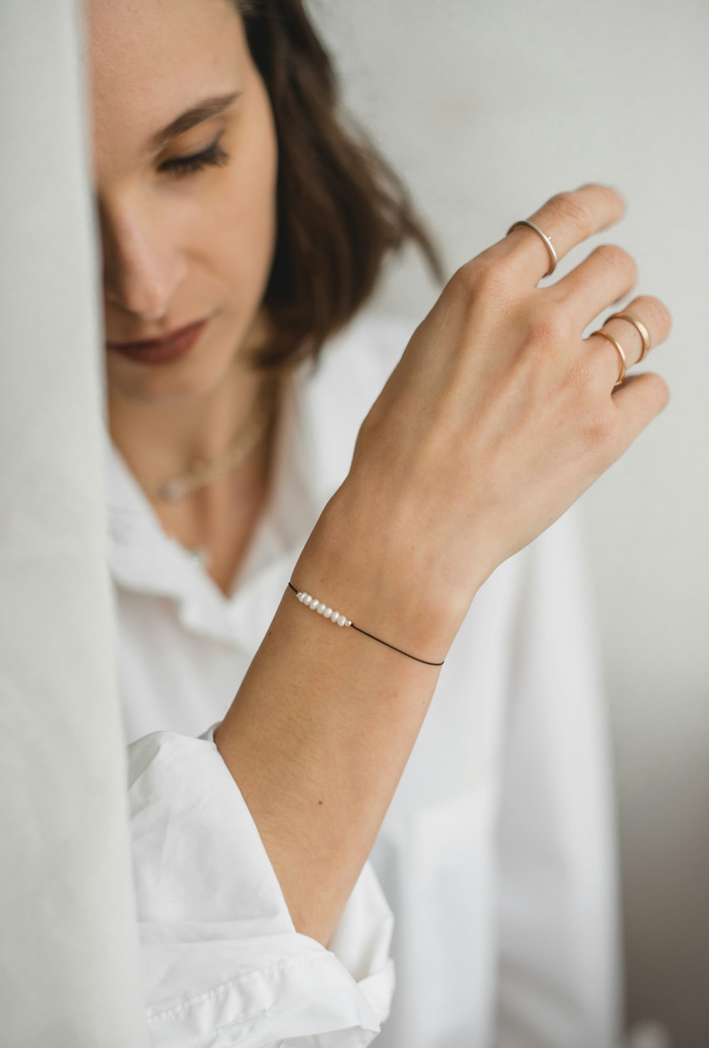 a woman wearing a gold bracelet and a white shirt