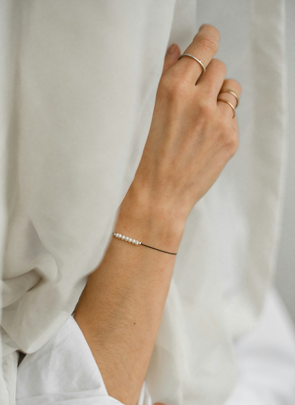 personne portant un bracelet en argent et une chemise blanche