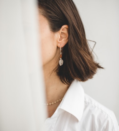woman in white shirt wearing silver earrings