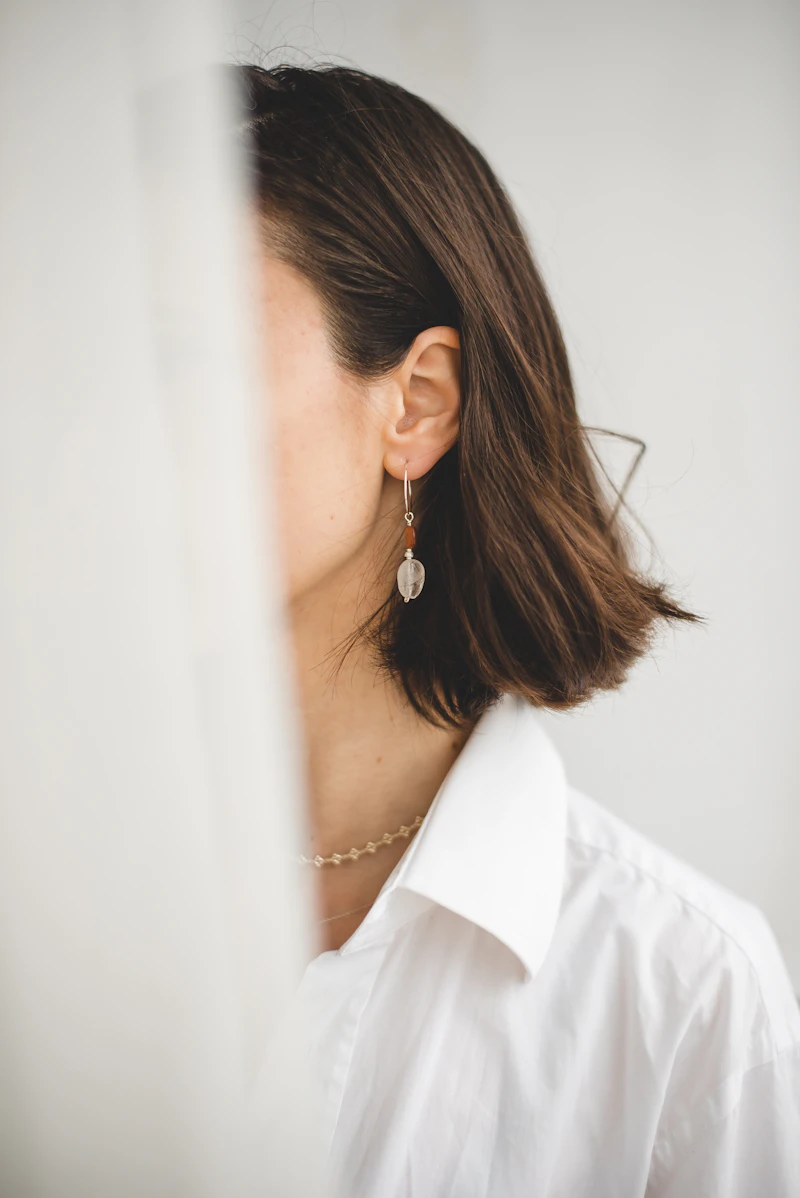 Adult woman with a short bob wearing a delicate drop earring