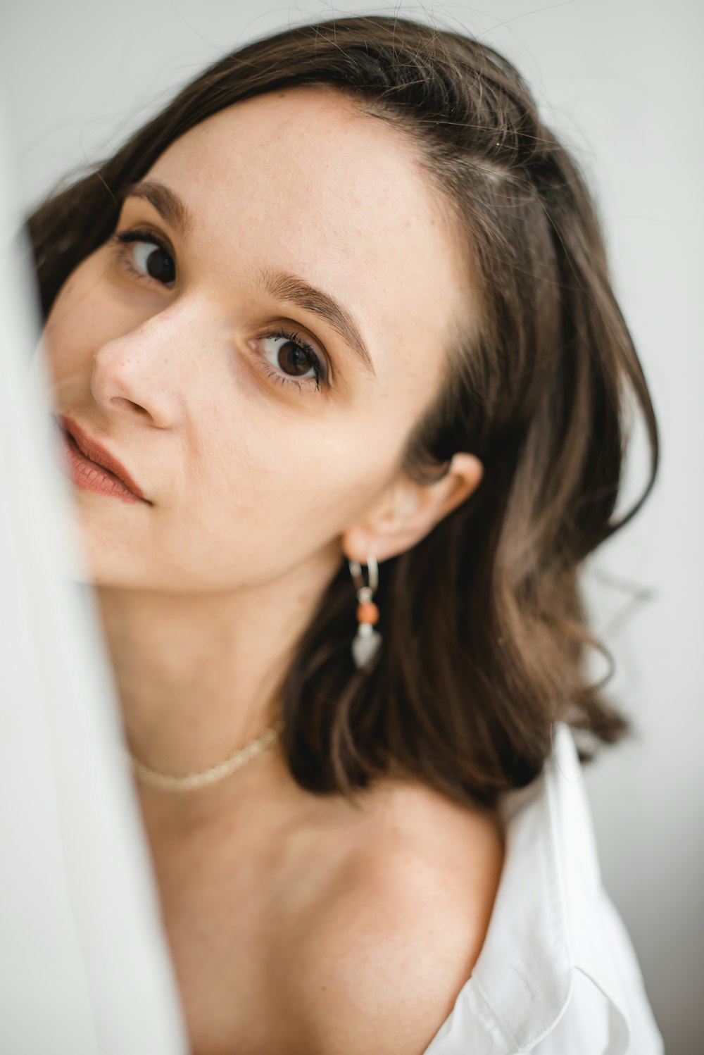 woman in white scoop neck shirt wearing silver and gold earrings