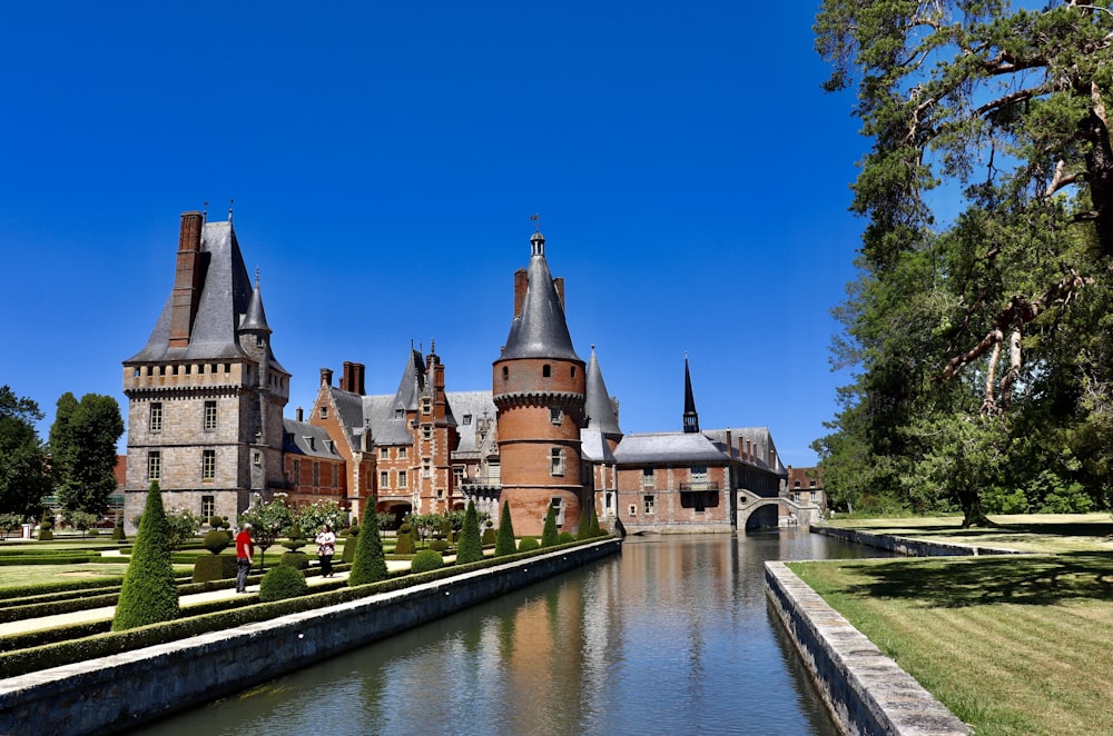 brown and blue castle beside river during daytime