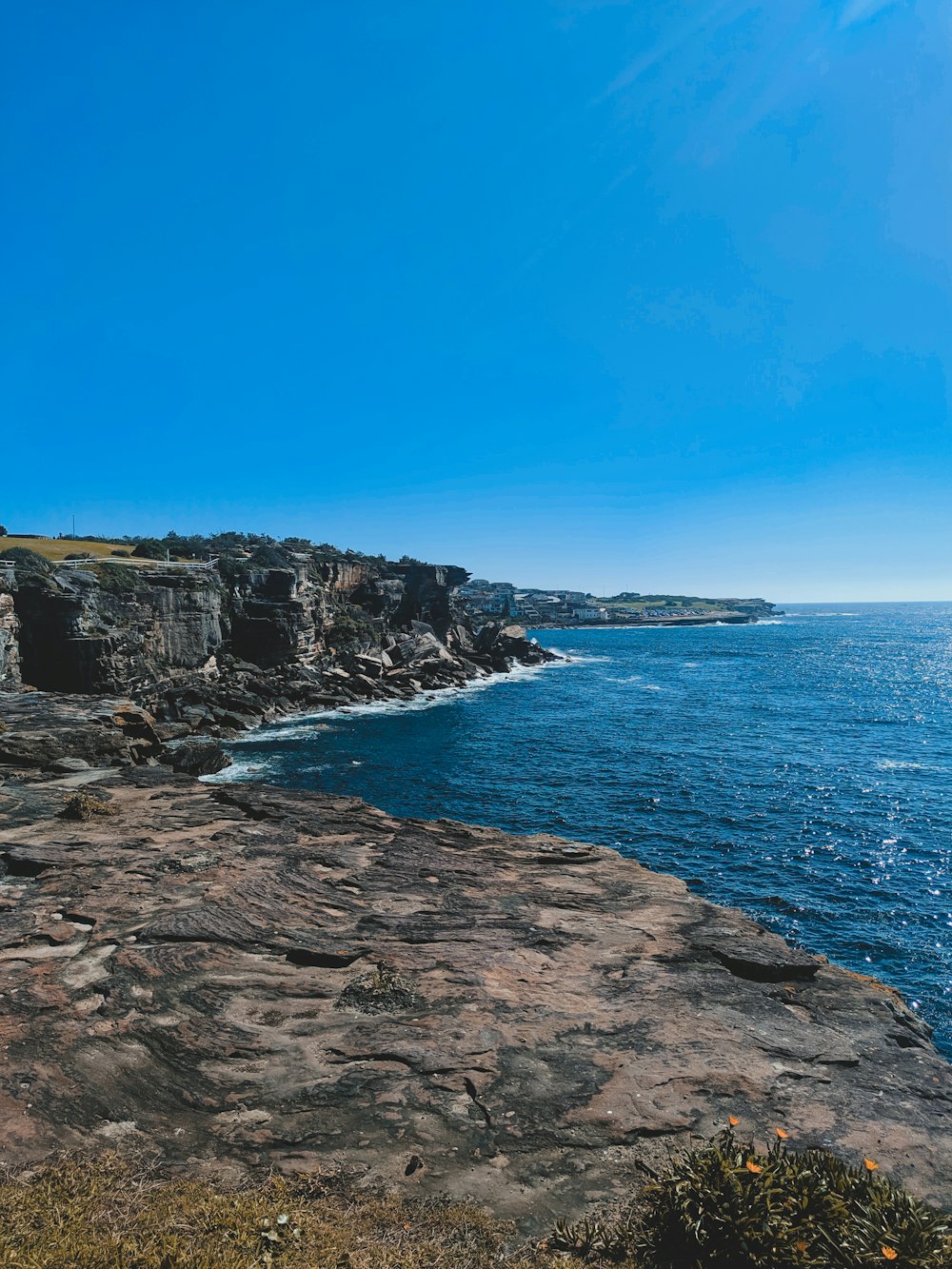 montagne rocheuse brune à côté de la mer bleue sous le ciel bleu pendant la journée