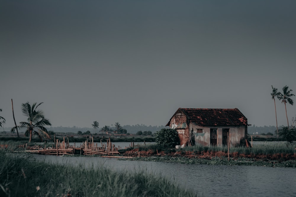 brown wooden house near body of water during daytime