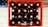 A red plastic crate contains 20 glass bottles, each topped with a metal cap featuring a green star symbol. The layout is viewed from above, showing the bottles neatly arranged in a grid pattern. The floor beneath is tiled in a light color.