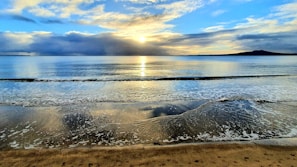 Evening view of the beach with calm waves and clear skies near the rental home