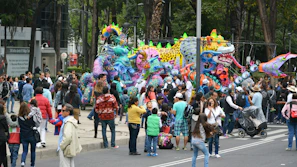 A bustling crowd admiring sculptures and installations at an outdoor heritage event.