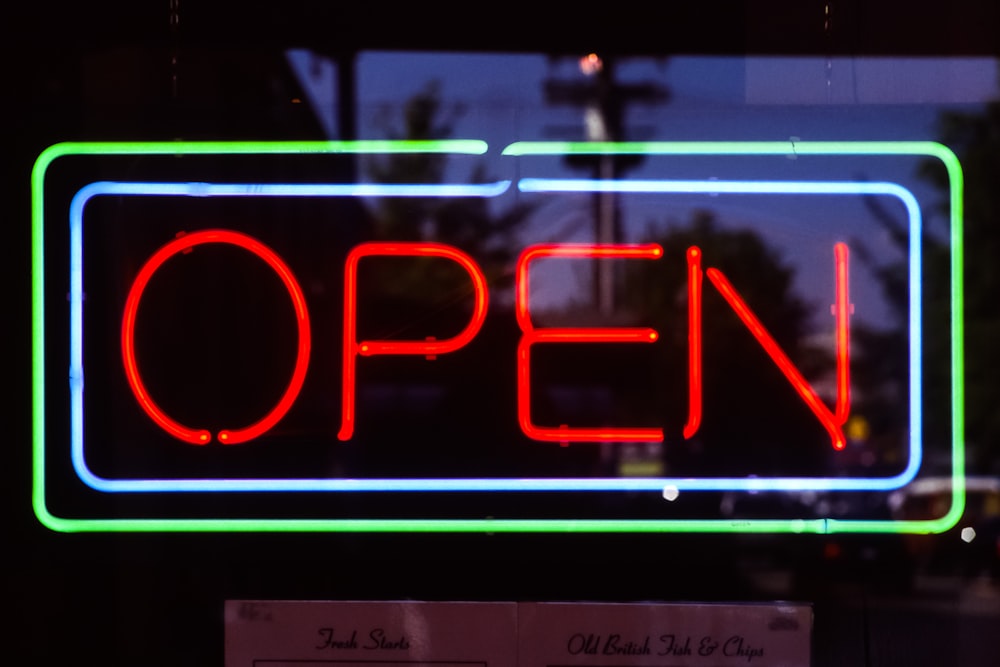 a neon sign that says open in a window