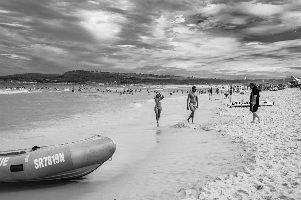 grayscale photo of people on beach